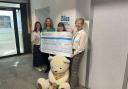Emma Ross (third from left) presenting the cheque at Bliss headquarters