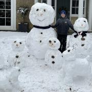 Zac Clark, 12, has been busy making a family of snow people and pets in Melbourn. Pic: Melanie Clark