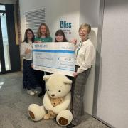 Emma Ross (third from left) presenting the cheque at Bliss headquarters
