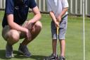 Marcus Karim, four, gets some putting tips from Kingsley Golf centre PGA professional Chris Hattersley. Picture: CALLUM ALLCOCK-GREEN