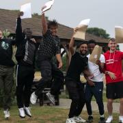 Students at Nicholas Breakspear Catholic School in St Albans jump with their A-level results envelopes
