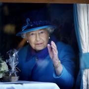 Queen Elizabeth II waves from a railway carriage in 2015