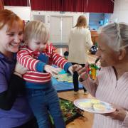 Louise Harding of Barkway Baby and Toddler Group with Hugo,  who was eager to get a cake from Melbourn Springs resident Chandra