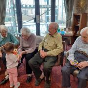 Yuna showing residents at Melbourn Springs Care Home her toys