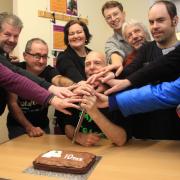 Royston Repair Café repairers cutting the cake to celebrate their 10th anniversary